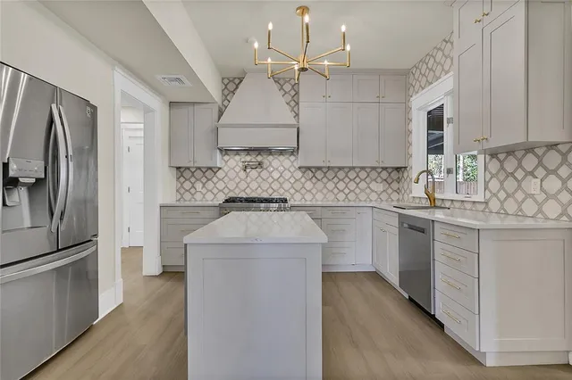 a view of a kitchen with a white cabinet and a stove top oven