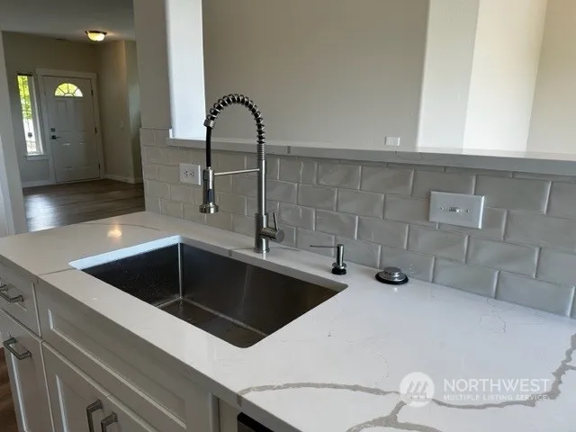 a kitchen with a sink and white cabinets