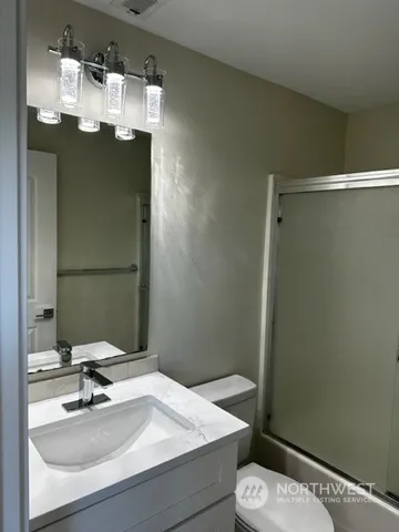 a bathroom with a sink a toilet and mirror