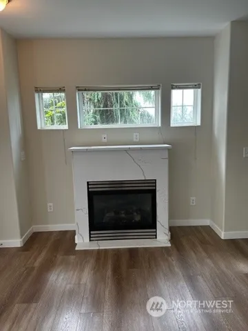 a living room with a fireplace and wooden floor