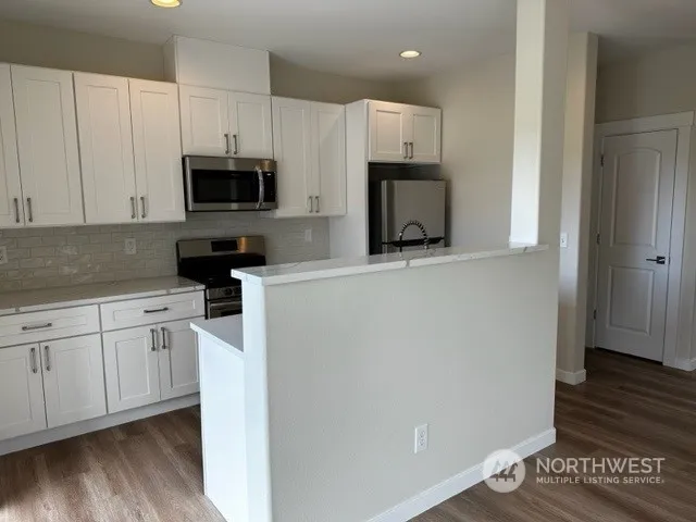 a kitchen with stainless steel appliances a microwave a sink and cabinets