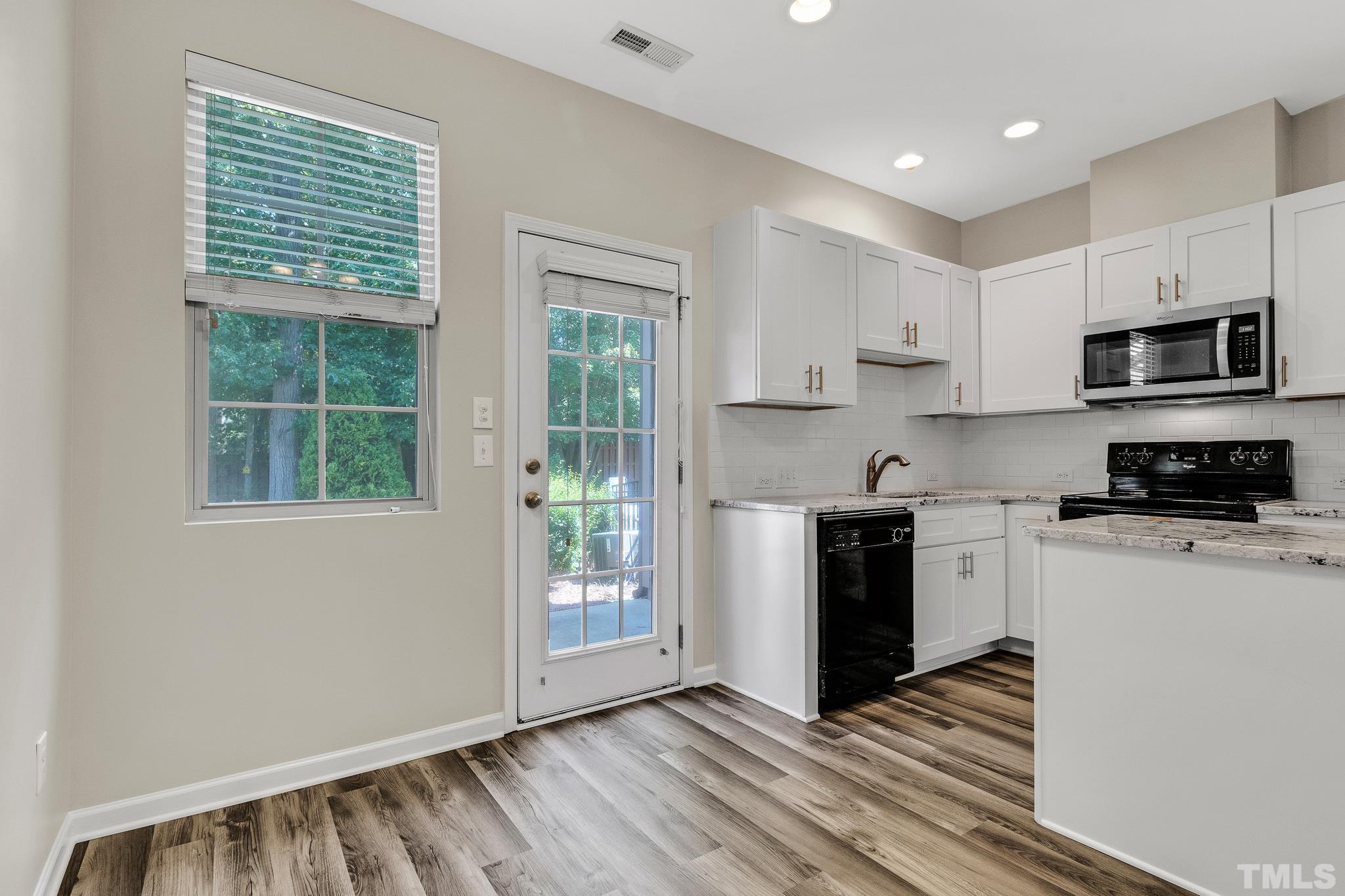 762 Wickham Ridge Road Apex, NC 27539 - Photo 12 of 32 a kitchen with stainless steel appliances granite countertop a stove a sink and a microwave