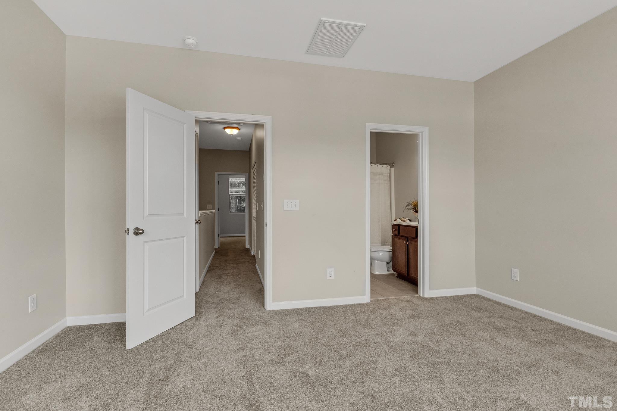 762 Wickham Ridge Road Apex, NC 27539 - Photo 22 of 32 an empty room with closet and a bathroom