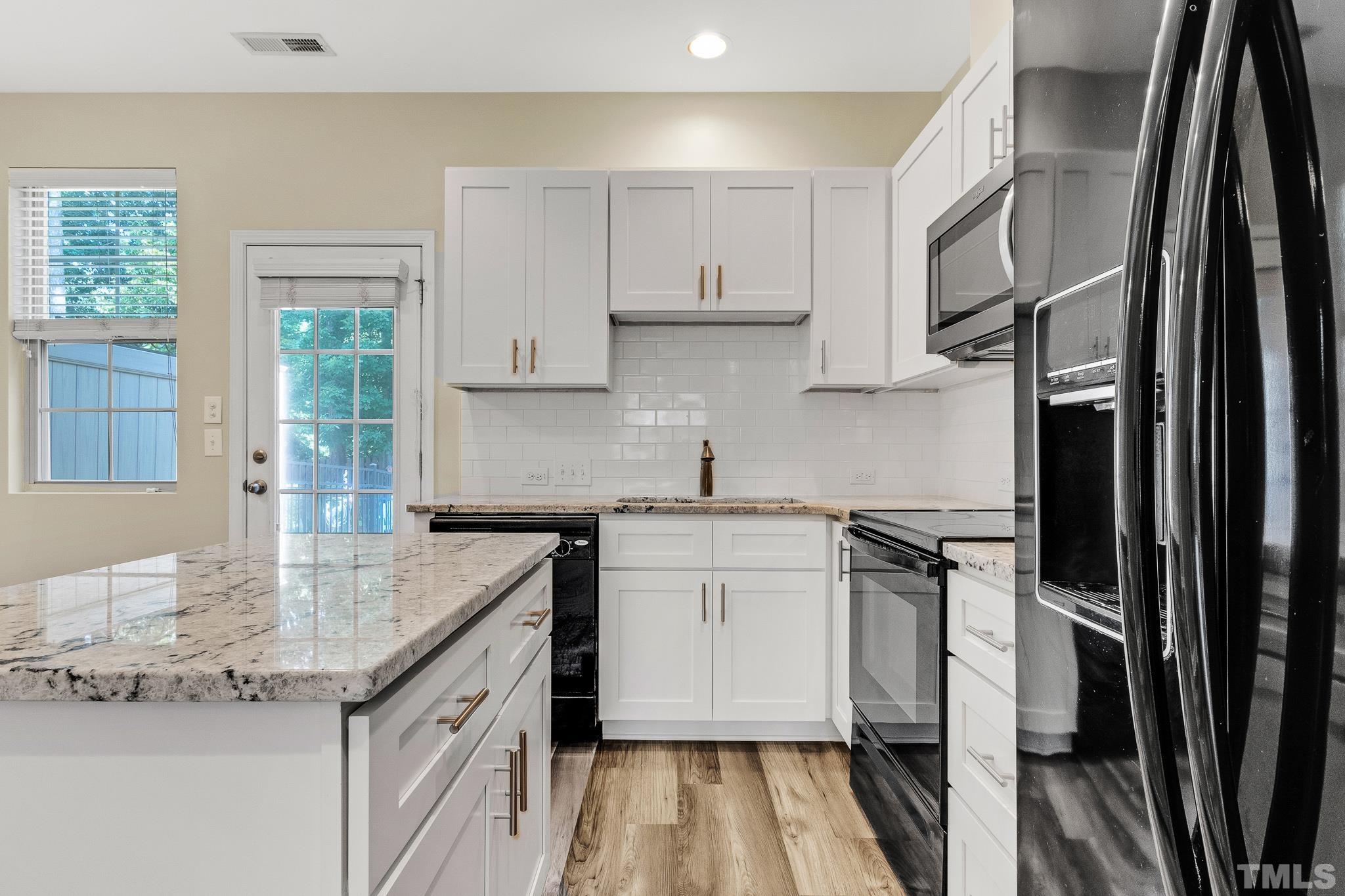 762 Wickham Ridge Road Apex, NC 27539 - Photo 7 of 32 a kitchen with granite countertop a sink stove and refrigerator