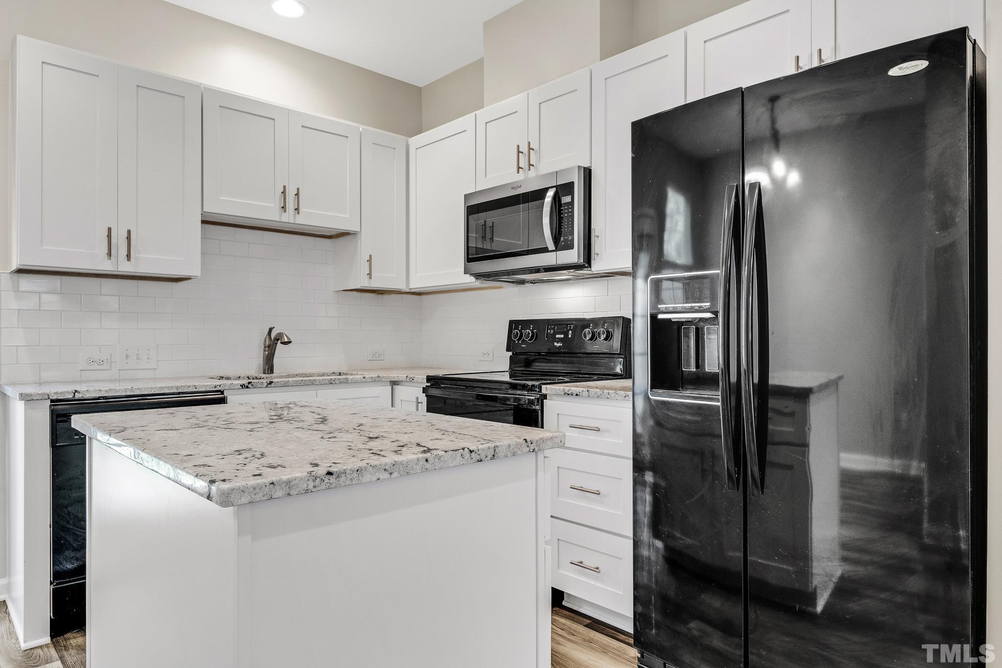 762 Wickham Ridge Road Apex, NC 27539 - Photo 9 of 32 a kitchen with stainless steel appliances granite countertop a refrigerator and a stove top oven