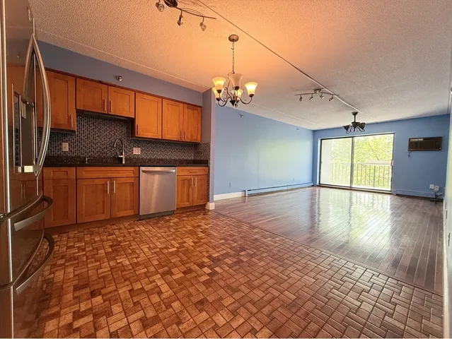 a kitchen with granite countertop a stove a sink and a refrigerator