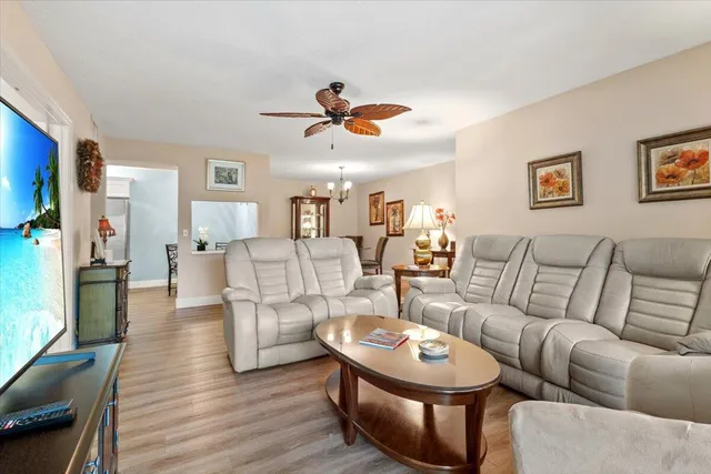 a living room with furniture a ceiling fan and a rug