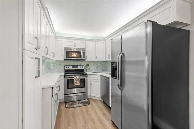 a kitchen with stainless steel appliances granite countertop a refrigerator and a stove top oven