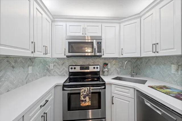 a kitchen with appliances a sink and cabinets