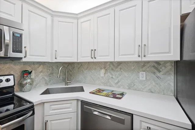 a view of a kitchen with white cabinets