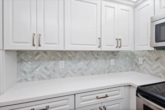 a view of kitchen with white cabinets and sink