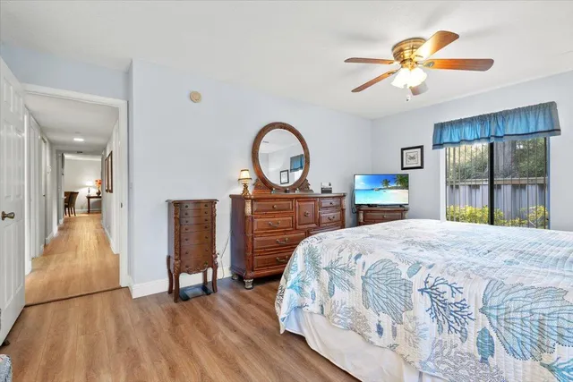 a bedroom with a bed and a large window with a chandelier