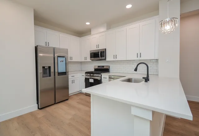 a kitchen with stainless steel appliances granite countertop a refrigerator stove a sink and a microwave