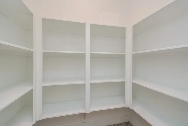 an empty room with a ceiling fan and a window