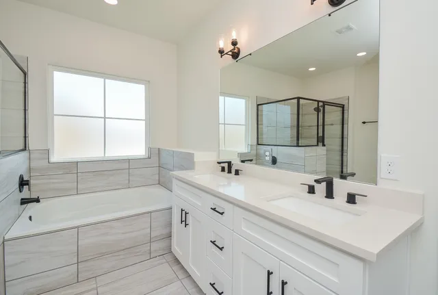 a bathroom with a double vanity sink a toilet a mirror and shower