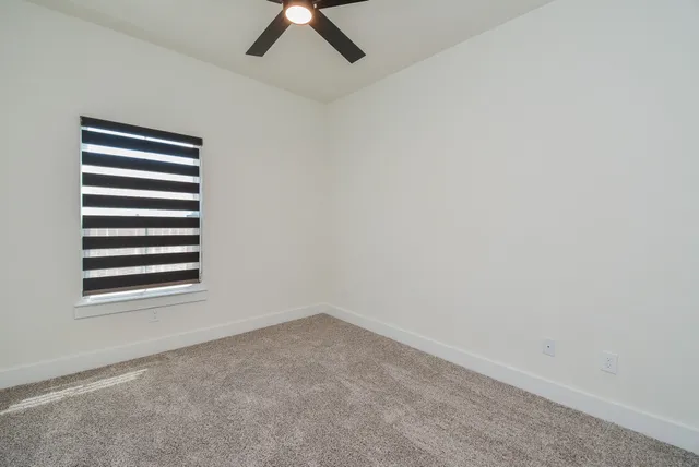 an empty room with closet and a chandelier fan