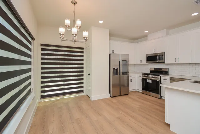 a kitchen with stainless steel appliances a refrigerator sink and microwave