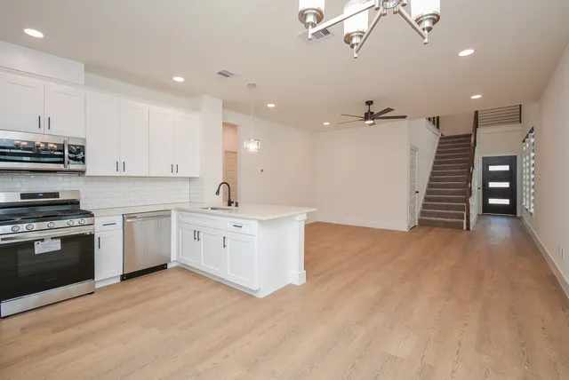 a kitchen with stainless steel appliances granite countertop a refrigerator and a stove top oven