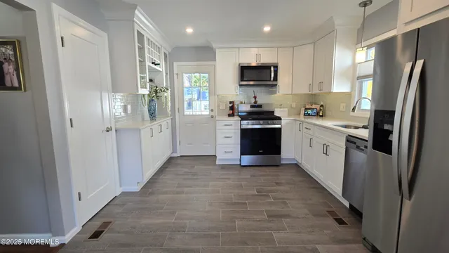 a kitchen with stainless steel appliances granite countertop refrigerator a stove top oven a sink and dishwasher