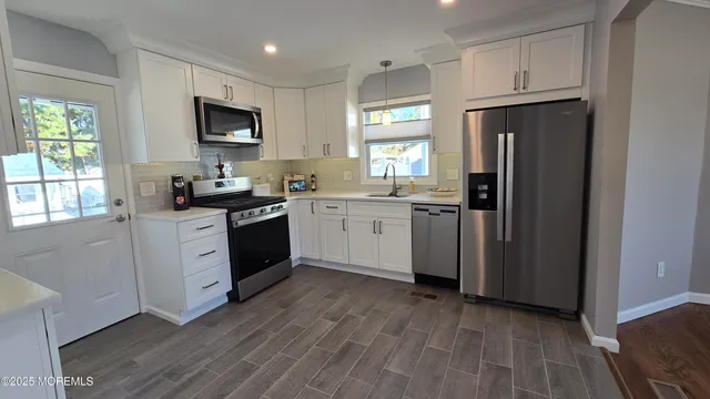a kitchen with white cabinets and stainless steel appliances