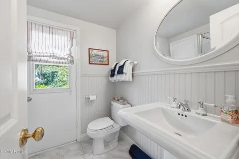 a bathroom with a sink a toilet and a mirror