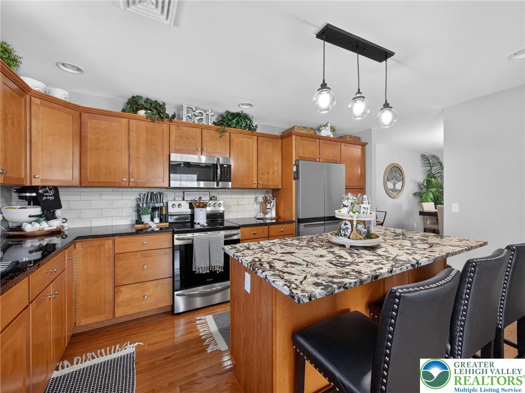 4148 Ross Road Bethlehem, PA 18020 - Photo 36 of 67 A well-appointed kitchen showcasing rich wooden cabinetry and a spacious granite island, perfect for gathering.