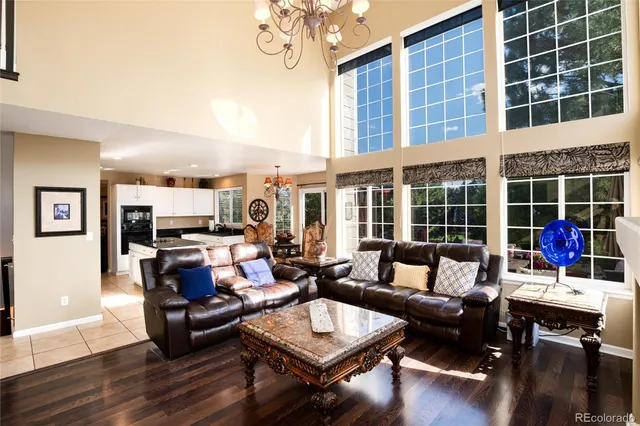 a spacious bedroom with a bed a chandelier and a couch