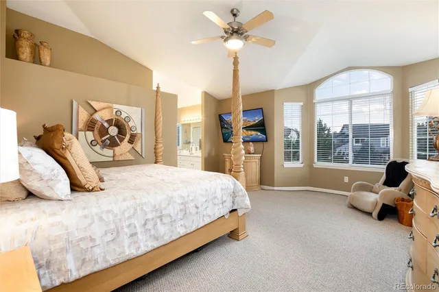 a bedroom with a bed a dresser and a chandelier