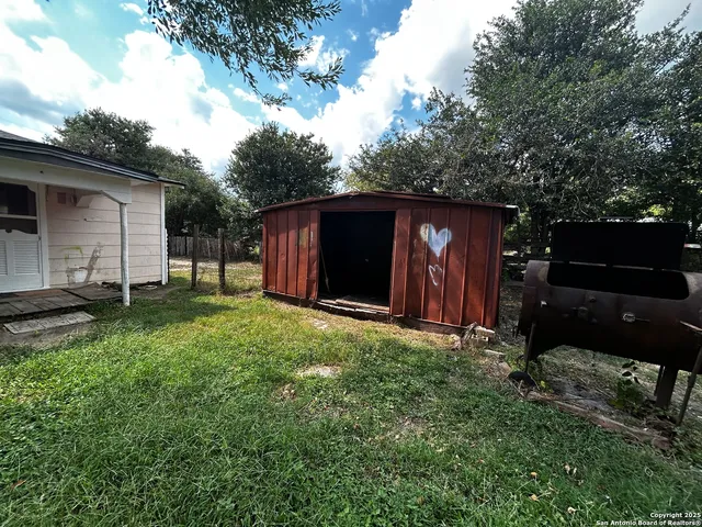 a backyard of a house with barbeque oven and table