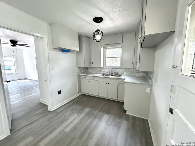 a kitchen with stainless steel appliances kitchen island granite countertop a sink cabinets and wooden floor