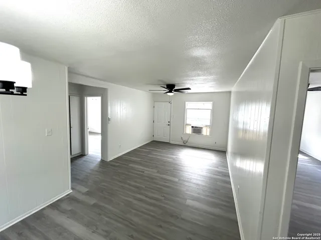 a view of empty room with wooden floor and window