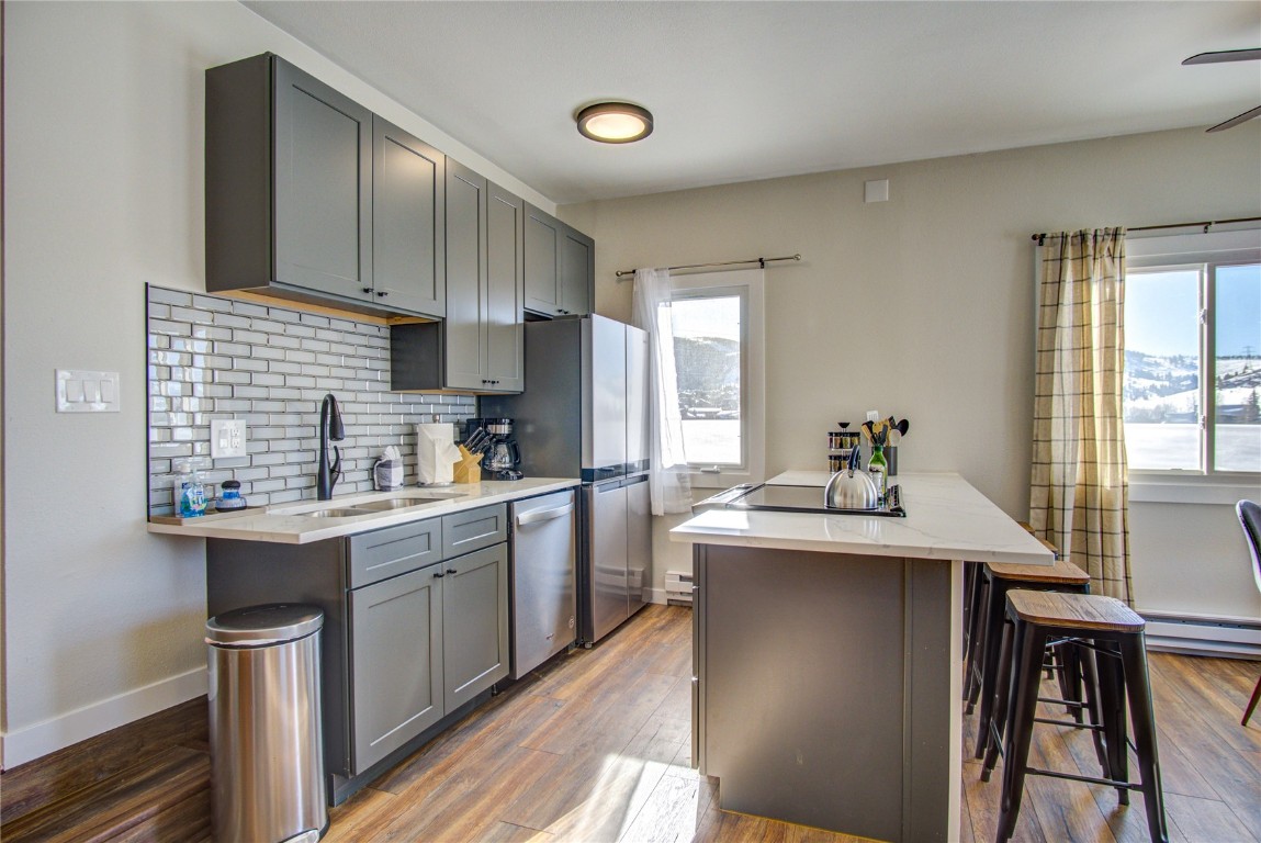78 Summit Drive, Unit C11 Dillon, CO 80435 - Photo 5 of 21 a kitchen with stainless steel appliances kitchen island a table chairs in it and wooden floors