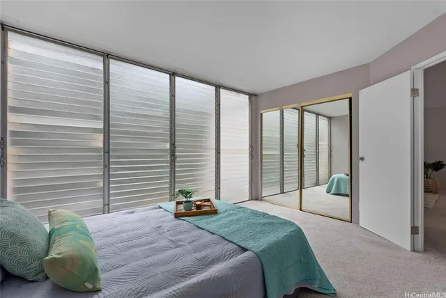 a bedroom with a bed and a large window