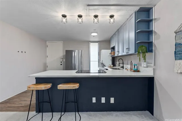 a kitchen with stainless steel appliances granite countertop a sink a stove and chairs
