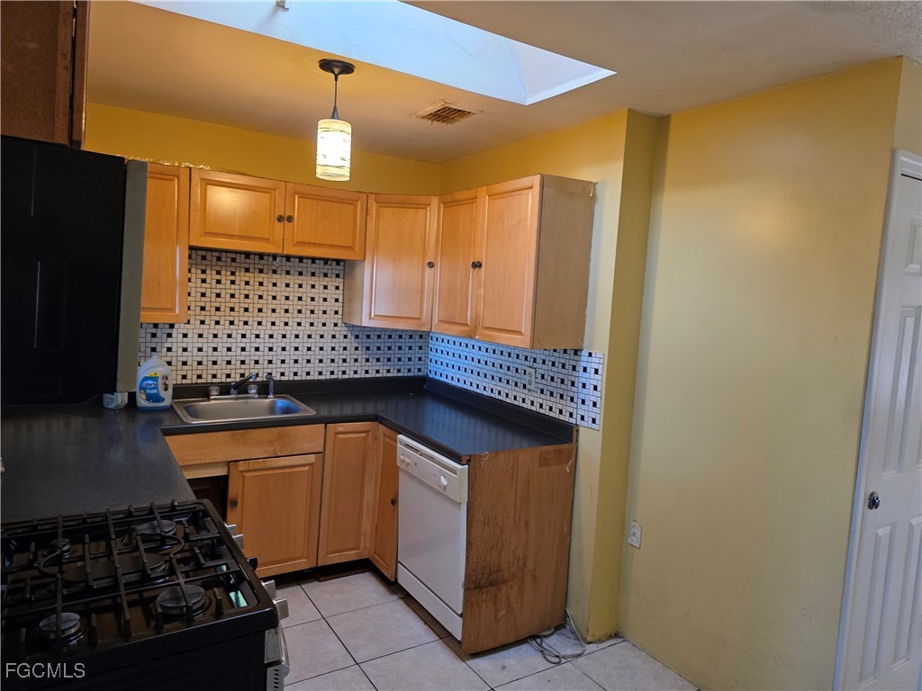 308 Stanford Street Lehigh Acres, FL 33936 - Photo 6 of 14 a kitchen with a sink and a refrigerator