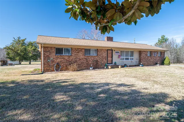 a front view of a house with a yard and potted plants