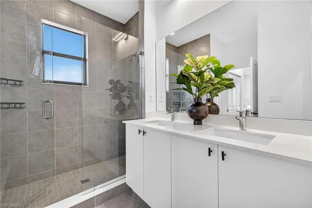 a bathroom with a sink a mirror and a shower