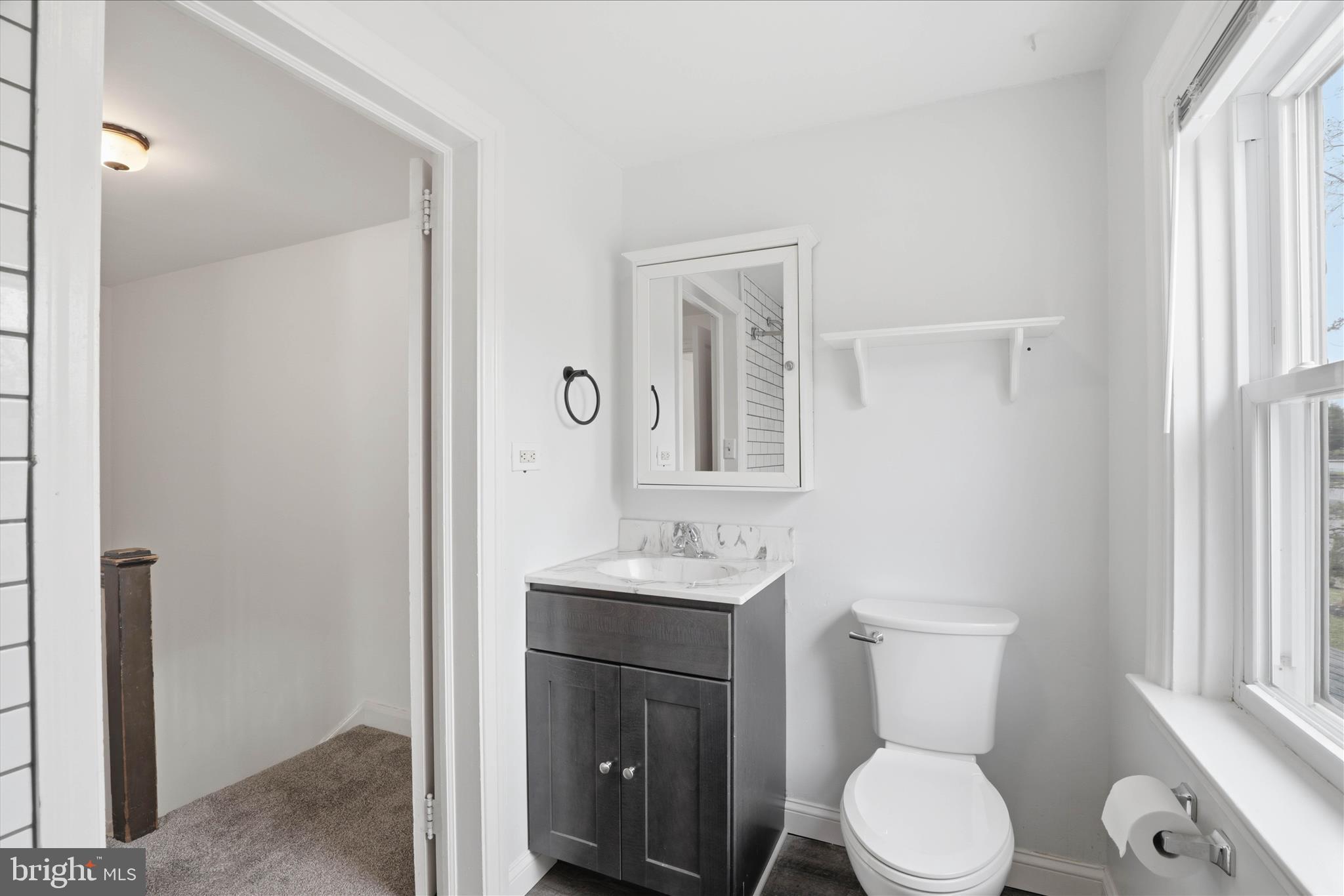 1630 Lampeter Road Lancaster, PA 17602 - Photo 26 of 49 a bathroom with a toilet a sink a mirror and a window