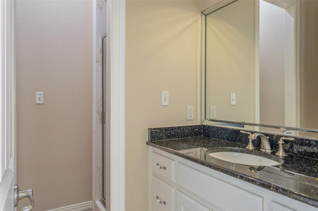 20389 County Road 178 Flint, TX 75762 - Photo 15 of 40 Bathroom vanity with an undermount sink, brushed nickel faucet, and a black speckled countertop