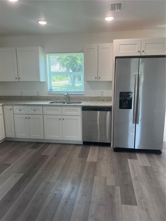 68 Evergreen Street Punta Gorda, FL 33982 - Photo 2 of 8 a kitchen with stainless steel appliances granite countertop a refrigerator a sink a stove a microwave and island with wooden floor