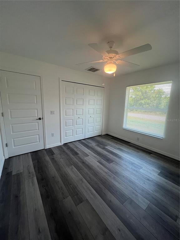 68 Evergreen Street Punta Gorda, FL 33982 - Photo 4 of 8 an empty room with wooden floor closet and windows