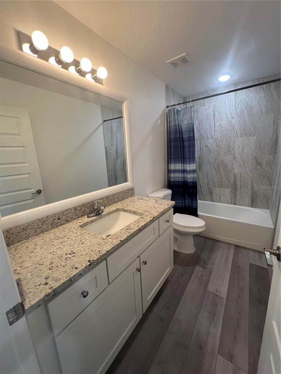 68 Evergreen Street Punta Gorda, FL 33982 - Photo 5 of 8 a bathroom with a granite countertop sink a toilet a mirror and bathtub