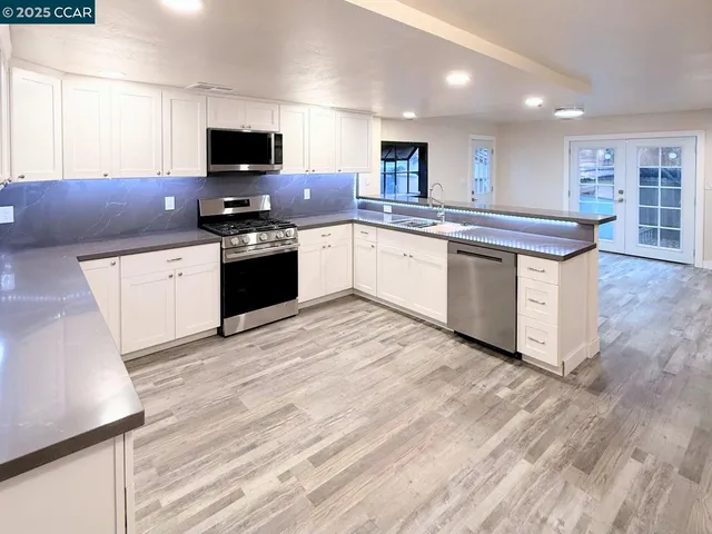 a kitchen with granite countertop a stove top oven and cabinets