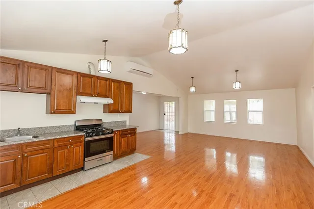 a large kitchen with stainless steel appliances granite countertop a stove and a wooden floors