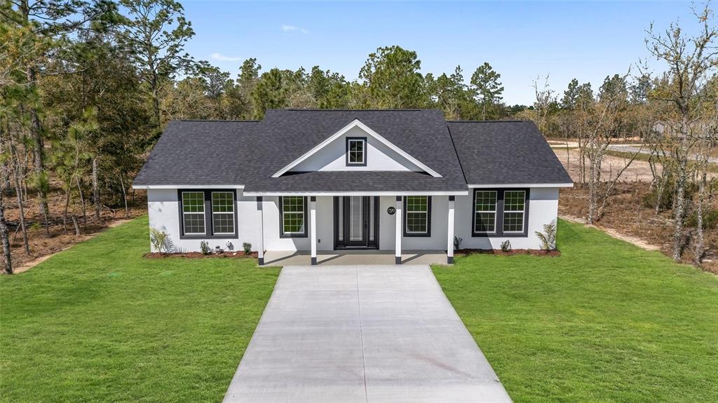 1370 Northeast 151 Avenue Williston, FL 32696 - Photo 1 of 51 a front view of a house with a garden and trees