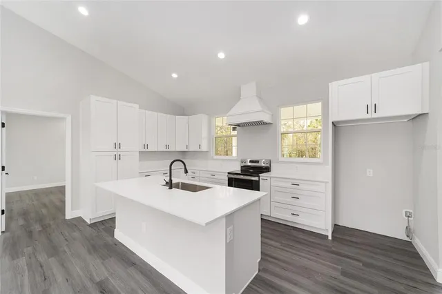 a kitchen with granite countertop a sink stove and cabinets