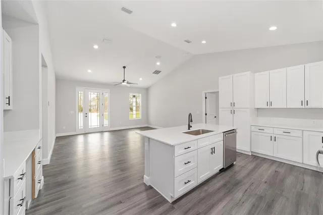 a view of a kitchen with a sink wooden cabinets and center island