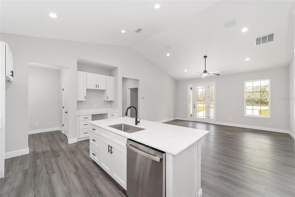 1370 Northeast 151 Avenue Williston, FL 32696 - Photo 20 of 51 a view of a kitchen with kitchen island a sink dishwasher a stove and a refrigerator with wooden floor