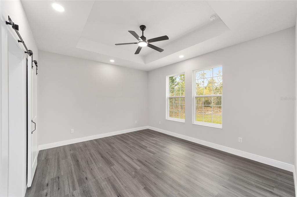 1370 Northeast 151 Avenue Williston, FL 32696 - Photo 21 of 51 an empty room with wooden floor fan and windows