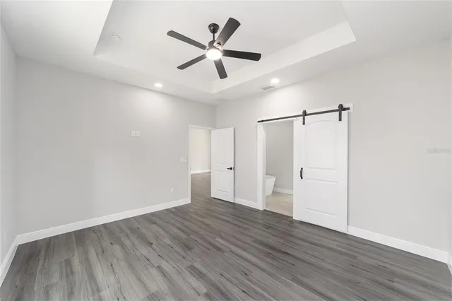 a view of a big room with wooden floor and windows